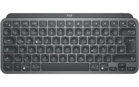 Die kompakte graphitfarbene Logitech MX Keys Mini kabellose tastatur mit Schweizer Layout auf einem dunklen Schreibtisch.