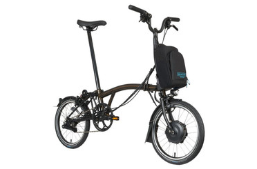 Ein zusammengeklapptes brompton electric c line in der Seitenansicht auf einem sauberen, hellen Hintergrund.